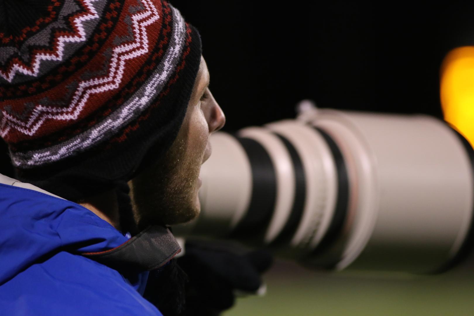 Meyer photographs a football game. He moved to the United States because his father's job was transferred.