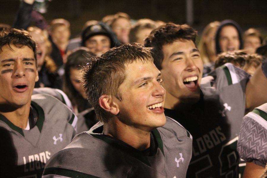 Celebrating with the crowd, Kasim Rana (18), Devon Thompson (18) , and Russell Gunhammer (18) enjoy the 28 - 17 win over the Evergreen Cougars in the annual Mountain Bowl matchup.  The win was the first for the Lobos in six seasons. Photo courtesy of Leslie Thompson