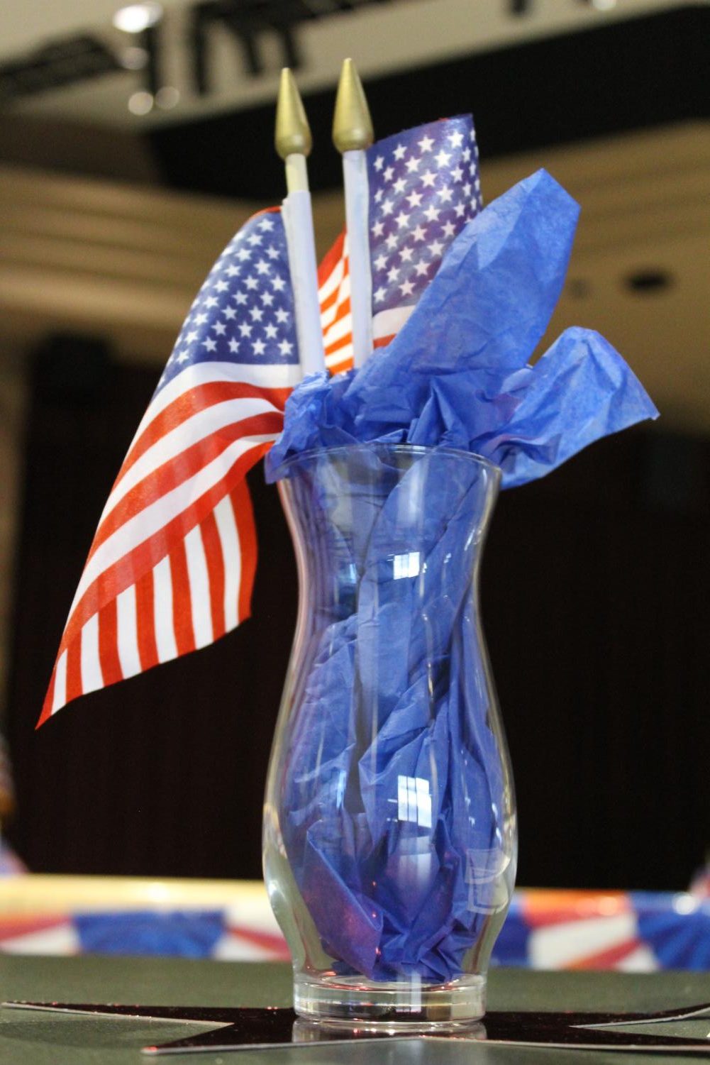 A vase holding mini American flags and blue tissue paper sits in the center of one of the cafeteria tables. Student government spent time putting up red, white, and blue decorations throughout the cafeteria, in honor of the upcoming holiday.
Photo courtesy of Katherine Ryan
