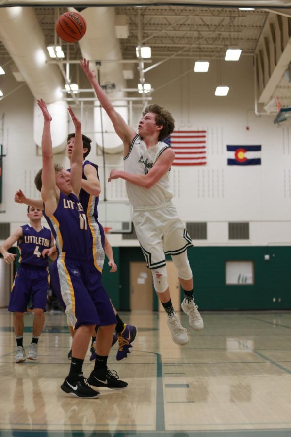 Junior Landon Wallace flies above a Littleton defender to score two of his six total points in the game on Tuesday, January 15.  The Lobos won, 58-55.
