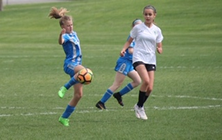 Working hard on the field, Ellie Chase keeps control of the ball.