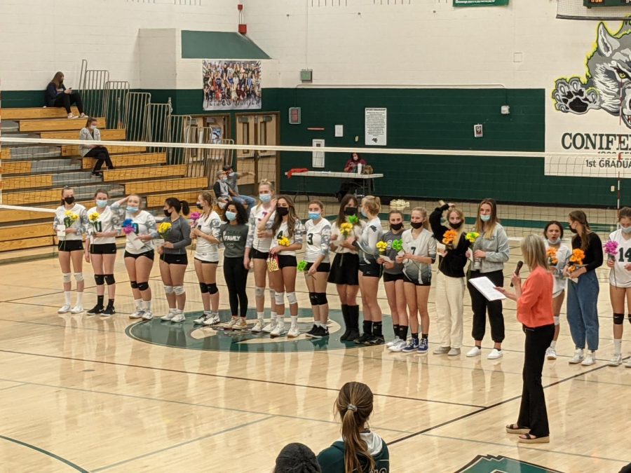 Lady Lobos Volleyball players stand by the net as coaches Eddy and Dan announce parents for parent appreciation.