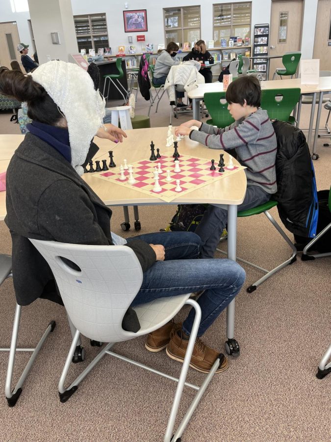 Sophomore Quinn Dastur and freshman David Glisson compete in a game of chess in the library in the hours before school begins.