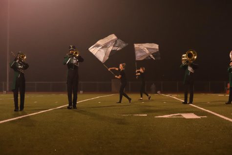 During the homecoming game, the band performs their first and second movement for students to see. Halfway through the first movement, the colorguard puts their flag behind them and has to unwind their arms before getting ready to throw it parallel above their heads.