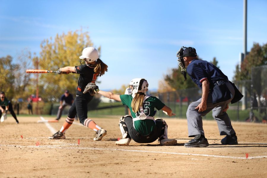 An Umpire officiates a game as a Conifer pitcher gets a strike on an opposing team.