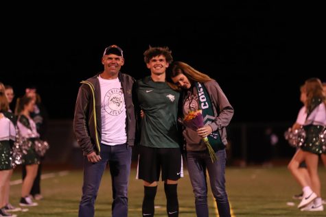 Senior Maddox Rife smiles proudly whilst gazing into the crowd with his parents. Rife is being recognized for his contribution to the team on Senior Night before his last high school game ever. Rife gained 33 points for the team this year and had the top assist rate, with 11 assists overall this season.