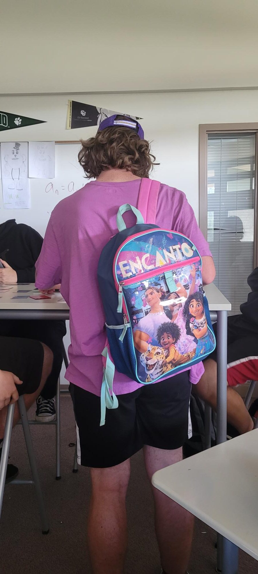 Senior Hayden Hinton at the beginning of the school day in Lobo Lab sports a child-sized backpack that displays characters from the Disney film “Encanto”. These small backpacks vary in color and appearance, but one constant seems to be that the school bag must be several sizes too small for its wearer.