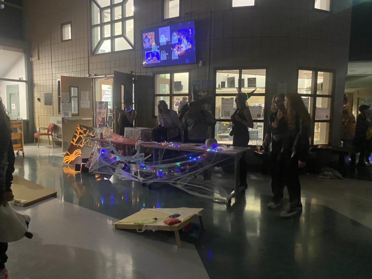 The yearbook staff booth with their halloween game, cornhole. They decorated their booth with lights, spider webs, and all dressed in witch costumes. This was just one of the many booths passing out candy for the Conifer community.
