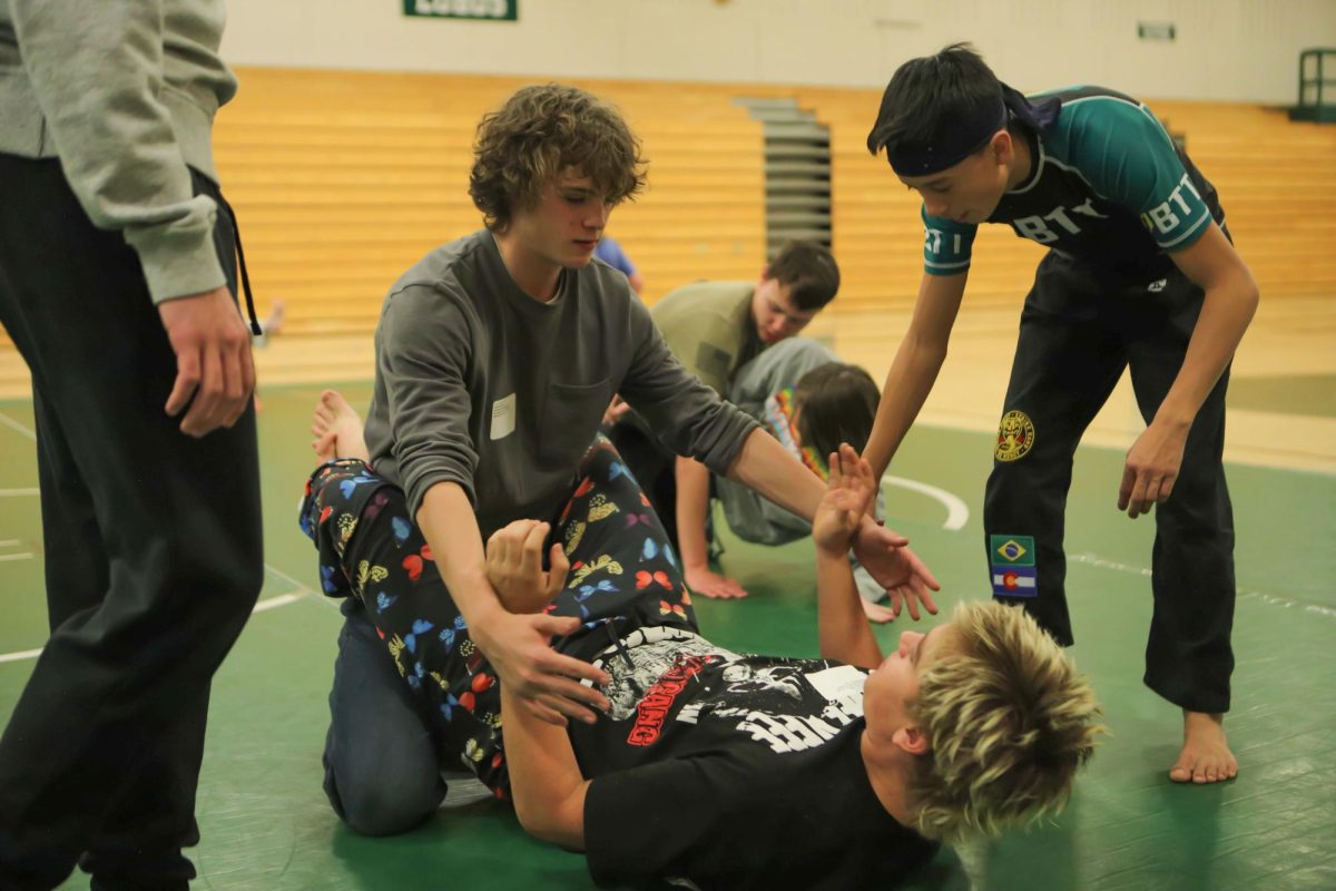 Brazilian Top Team (BTT) member helps sophomores Lucius Johnsen and Skylar Knight learn Brazilian Jiu Jitsu. BTT has locations across the country, founded in April 2000 to develop and create new training methodologies for sports jiu-jitsu, submission & grappling, wrestling and mixed martial arts. They have locations in both the Conifer and Evergeen Safeway centers, allowing those in the mountain community to learn a range of martial arts. [Quote]