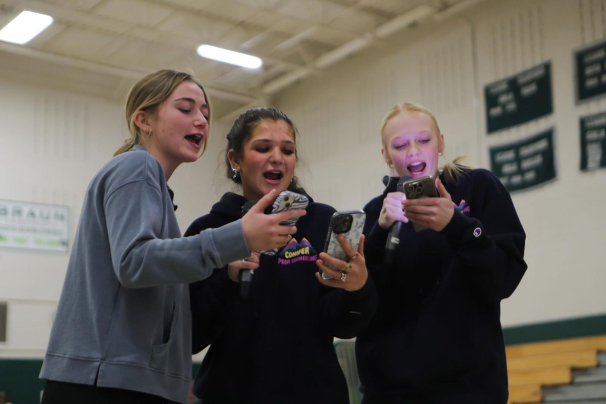 Seniors Sidney Rogozinski, Rosie Gumina, and Sydney Aikin sing their 'Peace Day Rap' during the Peace Day opening ceremony. The seniors are all part of the peer ambassadoring program, a Conifer-exclusive program that has juniors and seniors be directly involved in school and community activities, spirit, and organization. "We live in a pretty small community where there's not a lot of diversity, so I really enjoy getting to hear other people's perspectives," Gumina said.
