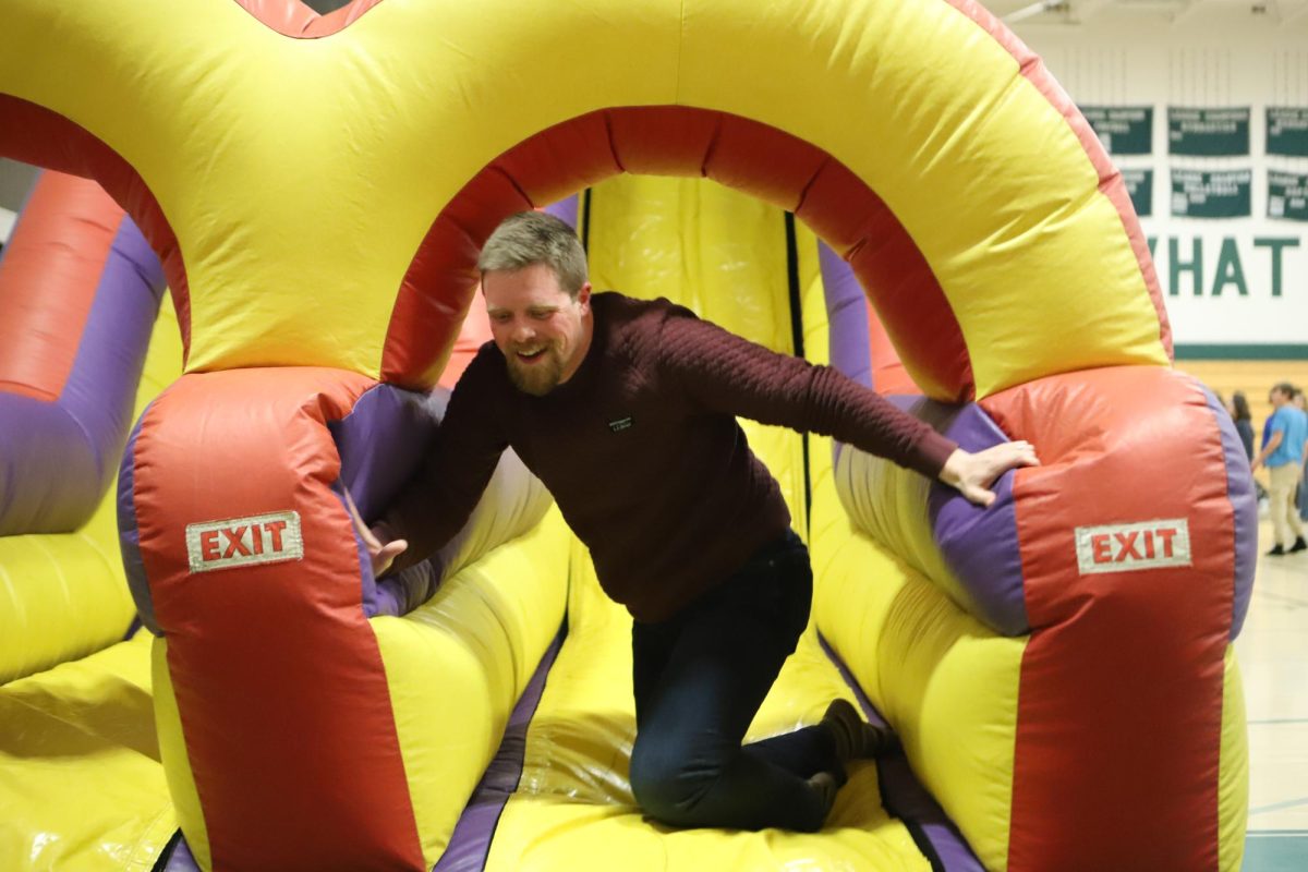 Teacher Owen Volzke exits the bouncy house-race course during lunch on Conifer's Peace Day. Students spent their on-campus lunch eating from food trucks, spending time with friends, and racing through the bouncy house which had dozens of racers. “I think it’s an opportunity to learn about stuff they don’t even know they don’t even know, and that offers this new perspective of the world,” Volzke said.