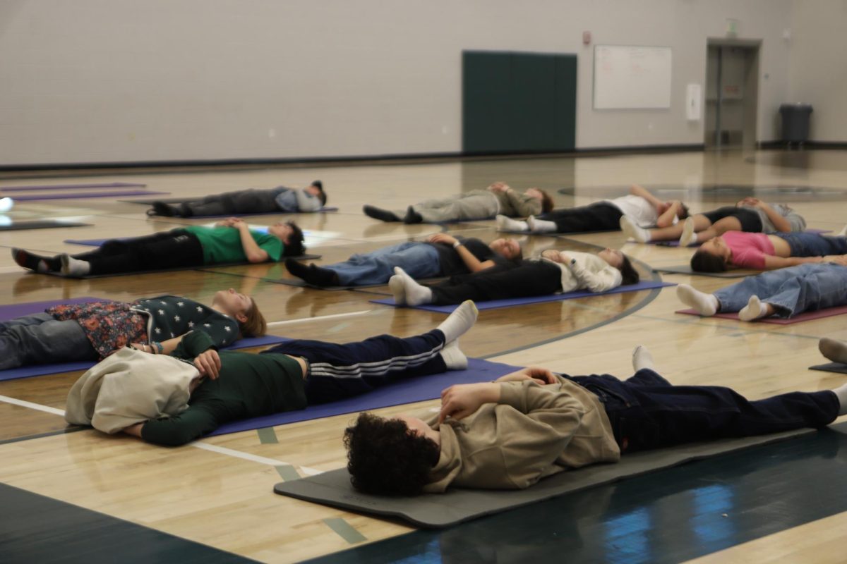 Students in the yoga workshop engage in guided meditation. On Peace Day, Cara York came to help students practice mindfulness and relaxation through peaceful meditation. [Quote]
