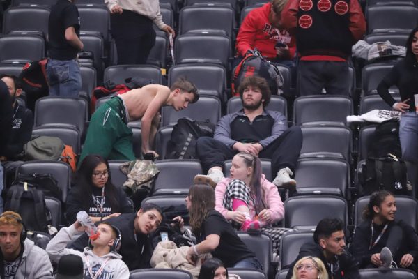 Senior Ben Metzger sits in the Conifer section during his state wrestling championship at the Ball Arena in Denver. Ben had just finished his wrestling match and was watching the other matches in the stands.