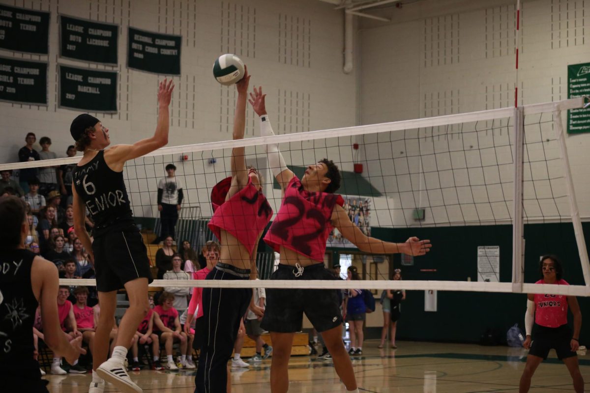 Senior and junior players reach for the volleyball during the Oct. 16 muscle match game, that which the seniors won. Another homecoming tradition, muscle match has the seniors play against the juniors in a boys volleyball game. 