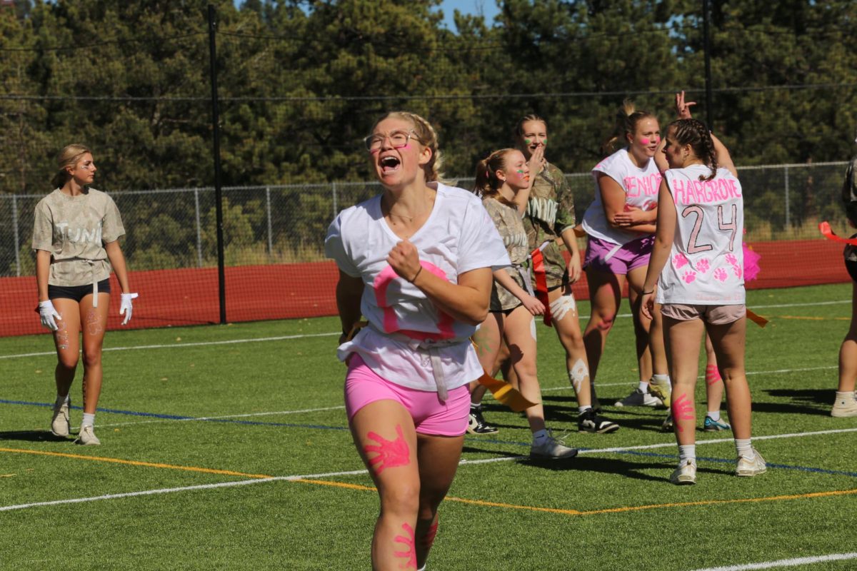Senior Cece Johns celebrates after a touchdown during the Oct. 14 powderpuff game that which the seniors won. A homecoming week tradition, powderpuff is a flag football game played by senior and junior girls. 