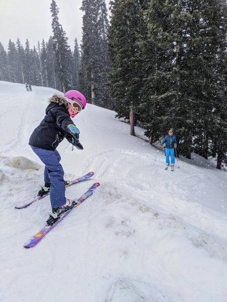 Nelson skis a snowy hill on a cold day, pointing to the camera as she is about to slide down. (Courtesy of Sofia Nelson)